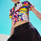 A colorful 90s-style mesh crop top featuring a maximalist abstract pattern. This see-through shirt has a high mock neck, short sleeves, and a vibrant, retro design with geometric shapes, color blocking, and polka dots in bold shades of pink, yellow, blue, and orange. The Y2K-inspired top is a statement piece of festival clothing, perfect for a rave outfit or alternative, dopamine-dressing-inspired streetwear looks.